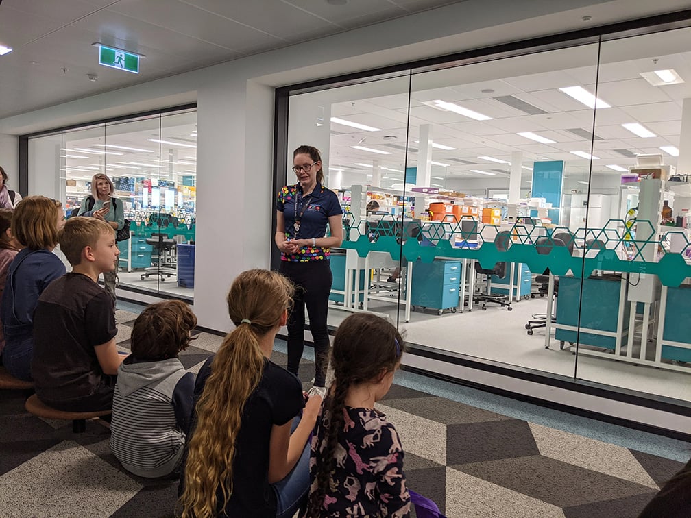 Image of researcher talking to children in front of Telethon Kids laboratories